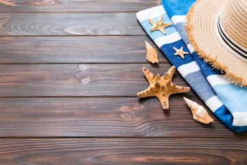 Straw hat, blue towel and starfish On a dark wooden background. top view summer holiday concept with copy space