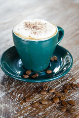 A cup of hot fresh coffee with rich foam on the wooden table