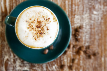 A cup of hot fresh coffee with rich foam on the wooden table