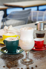 A cup of hot fresh coffee with rich foam on the wooden table