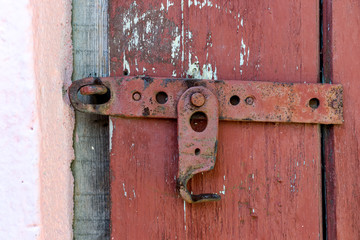 Wooden dirty red blank aged door for backdrop with rusty latch - closeup