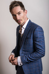 Elegant young handsome man in stylish blue costume. Studio fashion portrait.