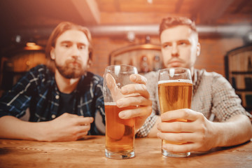 Two disappointed men sit in bar with beer and tell problems each other. Concept of insult and...