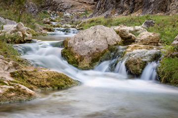 Smooth, silky water of long exposure mountain creek in a canyon, close up