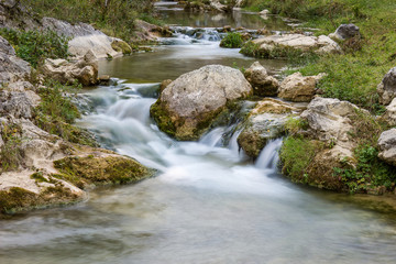Smooth, silky water of long exposure mountain creek in a canyon, close up