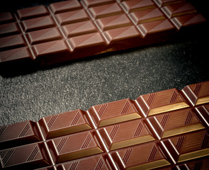 Black chocolate bar on black slate plate