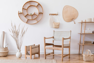 Stylish and cozy interior of living room with a lot of rattan accessories, design armchair, wooden shelf, flowers in vase. Korean style of home decor. Hanging rattan snail with airplants. Template. 