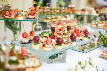 Catering. Off-site food. Buffet table with various canapes, sandwiches, hamburgers and snacks.