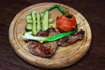 meat with vegetables on a wooden tray