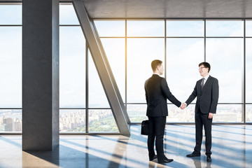 Businessmen shaking hands in meeting room