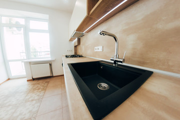 modern kitchen with neon lighting. chromed faucet and black square sink.