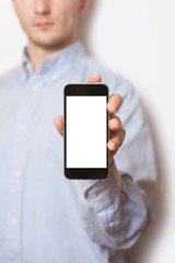 Portrait of casual men showing blank telephone screen while standing of white background
