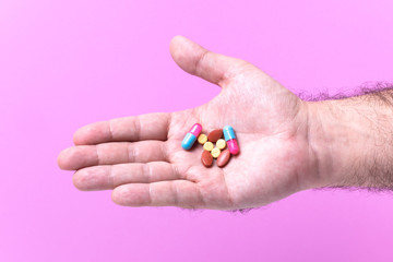 Close-up of hand holding pharmaceutical pill .