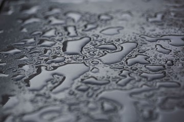 Beautiful background texture of rain water drops on grey black metal surface. Beautiful backgrounds.