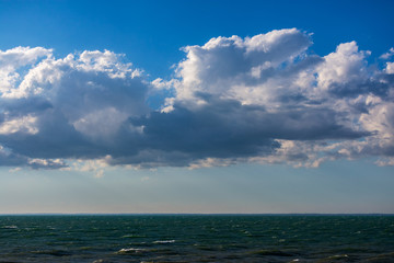 Clouds over water. Clouds against a blue sky. Blue sky with clouds on a sunny day.