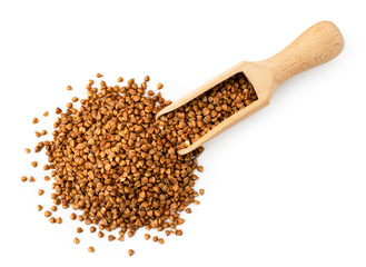 Buckwheat spilled from a wooden spoon on a white. The form of the top.