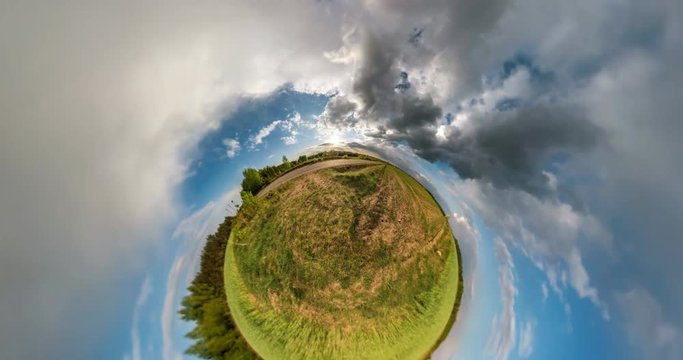 NO VR. Curvature of space of little planet transformation. Abstract torsion and spinning of full flyby panorama landscape in field near asphault road in sunny evening with awesome clouds.
