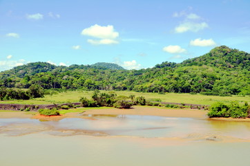 Green landscape of the Panama Canal, view from transiting container ship.