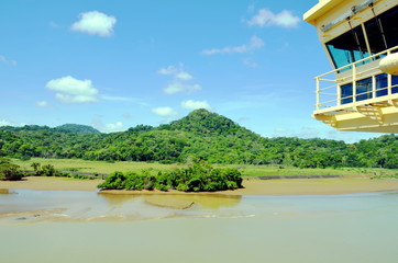 Green landscape of the Panama Canal, view from transiting container ship.