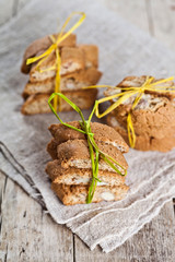 Fresh Italian cookies cantuccini with almond seeds on linen napkin on ructic wooden table background.