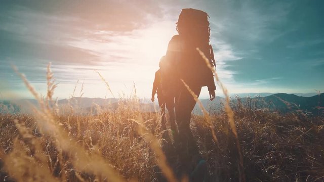 The couple walking in mountains on the sunny background. slow motion
