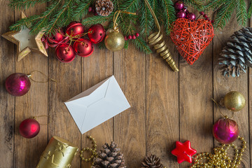 Beautiful Christmas decorations and white letter envelope on the rustic wooden background