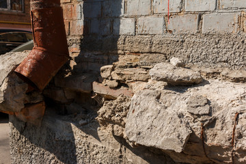 Fototapeta premium broken wall exterior of the house. broken portico of the house. Close-up view of an old wall abandoned. Architecture detail of damaged house wall.