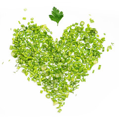 a green heart of chopped parsley and dill on white background