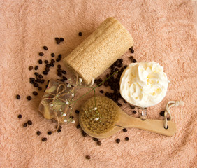 cosmetic concept with towel, brush, soap scrub, coffee beans, flower
