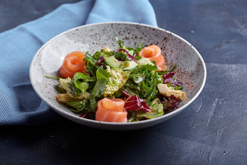 Salmon Salad with spinach, corn salad, baby spinach, fresh mint and basil. Home made food. Concept for a tasty and healthy meal. Dark stone background. Top view. Close up.