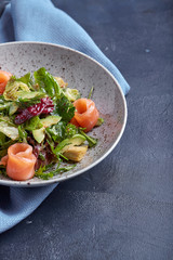 Salmon Salad with spinach, corn salad, baby spinach, fresh mint and basil. Home made food. Concept for a tasty and healthy meal. Dark stone background. Top view. Close up.