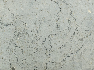 traces d'évaporation noires sur un sol en bitume gris