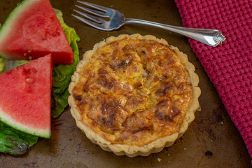 Quiche with watermelon and red napkin and fork
