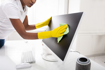 Woman's Hand Cleaning Desktop Screen