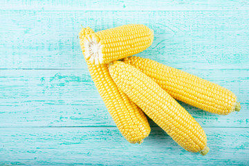 Fresh corn on cobs on rustic wooden table