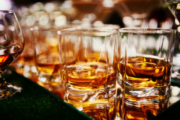 Glasses of whiskey on bar background. lots of glasses of whiskey. glasses of whiskey or brandy