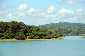 Green landscape of the Panama Canal, view from transiting container ship.