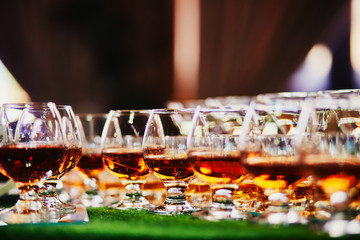 Glasses of whiskey on bar background. lots of glasses of whiskey. glasses of whiskey or brandy
