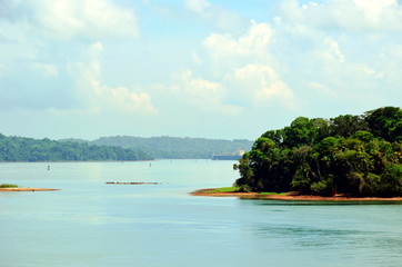 Green landscape of the Panama Canal, view from transiting container ship.