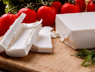 chopped feta cheese and tomatoes on a cutting board