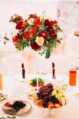 decoration of a banquet room on a wedding. Wedding in color Marsala. bouquets of flowers with red and white roses. guest seating board