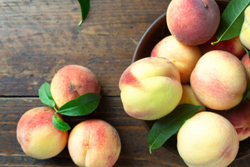 A group of ripe peaches in a bowl