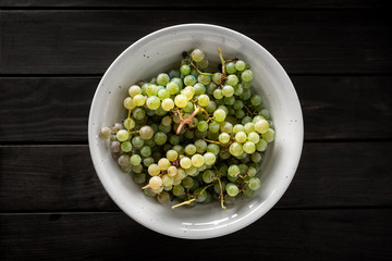 Top view of fresh white grapes in white bowl