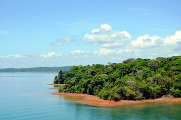 Green landscape of the Panama Canal, view from transiting container ship.