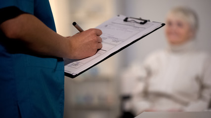 Doctor making notes in medical records, hospital examination, patient diagnosis
