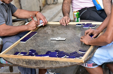 Hands of the cuban men playing domino in the street, a popular leisure game in Havana, Cuba
