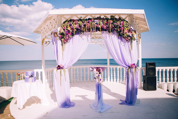 Obraz na płótnie Canvas wedding ceremony on the terrace by the sea. wedding decor in purple color.