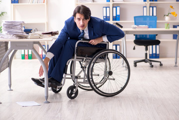 Young male employee in wheelchair working in the office 