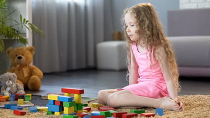 Naklejka premium Little girl playing with educational toy blocks, early development school