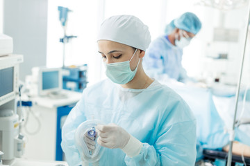 attractive nurse preparing oxygen mask for a patient, close up photo